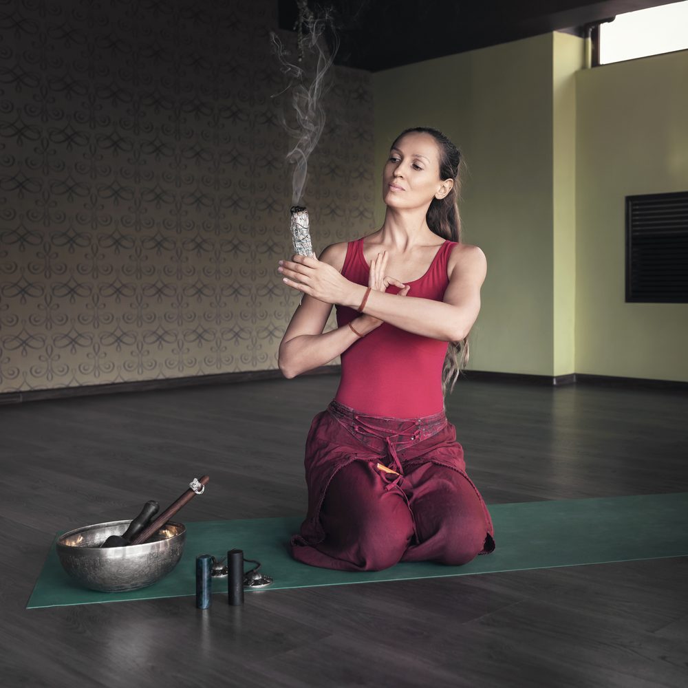 Personne ayant arrêté de fumer pratiquant doucement le yoga dans une pièce lumineuse.