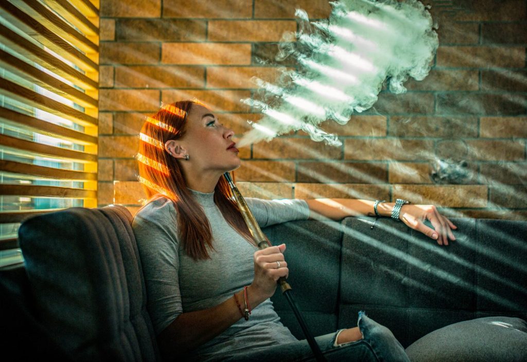 Personne assise en méditation avec un flacon d’e-liquide mentholé posé devant elle.